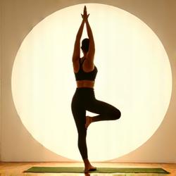 Una persona pratica una posa yoga fluida in uno studio luminoso